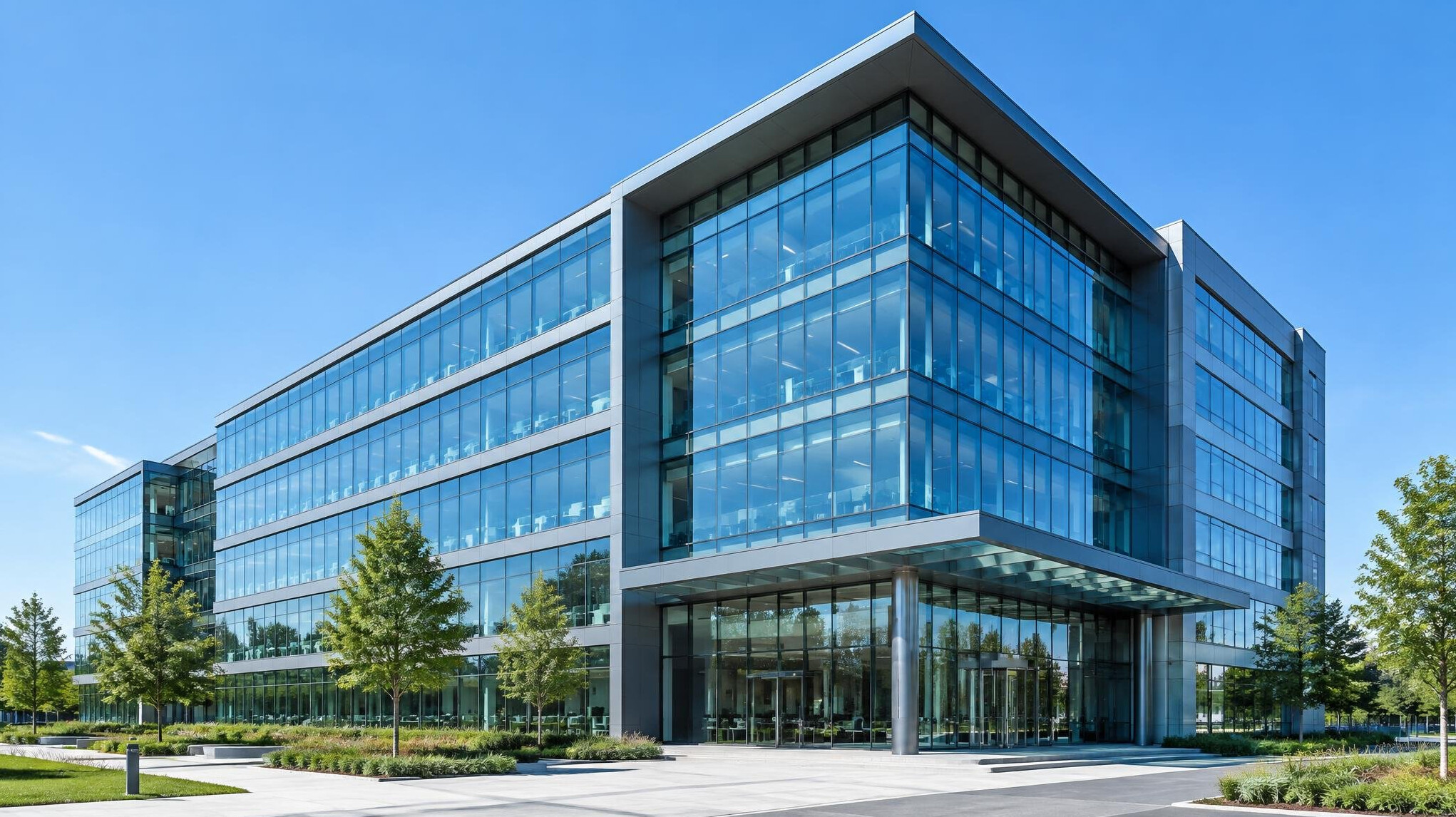 Modern glass office building exterior against a clear sky